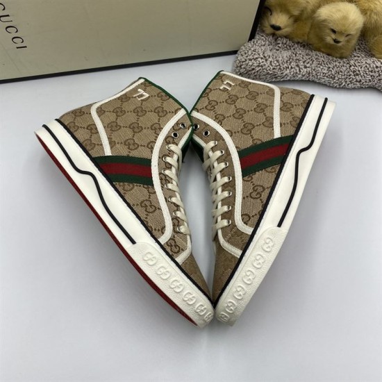 Pair of Gucci Tennis 1977 beige high top trainers angled showing sole edge embossed logo detail in beige and green