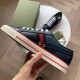 Hand holding a Gucci Tennis 1977 Low Top Blue Leather Trainer showing medial side profile