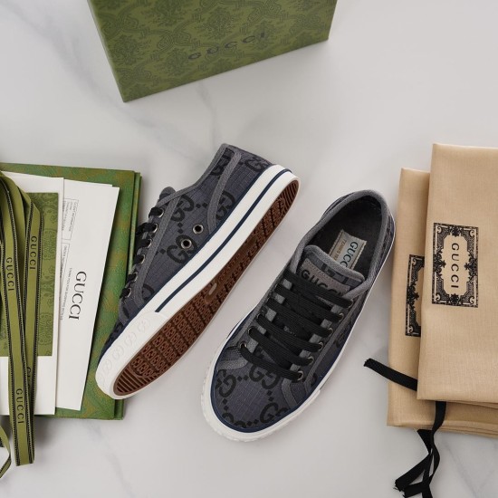 Overhead view showing one upright grey Gucci trainer and one lying on its side exposing sole