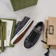 Overhead view showing one upright grey Gucci trainer and one lying on its side exposing sole