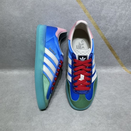 Gucci x Adidas Gazelle Trainer Arrangement in blue and white One blue Gucci x Adidas Gazelle trainer lying on its side next to another standing upright in blue and white