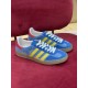 Pair of Gucci Gazelle Blue Suede Trainers in blue and yellow Pair of Gucci Gazelle blue suede trainers resting on red surface in blue and yellow