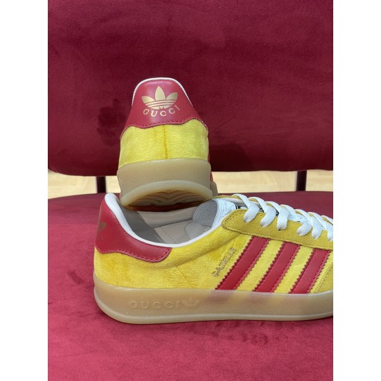 Rear heel view showing red leather heel tab and side quarter of Gucci trainers in yellow and red