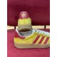Rear heel view showing red leather heel tab and side quarter of Gucci trainers in yellow and red
