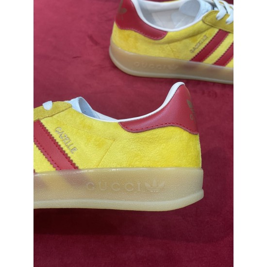 Detailed close-up of translucent gum sole and yellow velvet upper on Gucci trainer in yellow and red