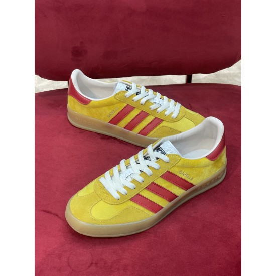 Top-down view of Gucci yellow velvet Gazelle low top trainers in yellow and red
