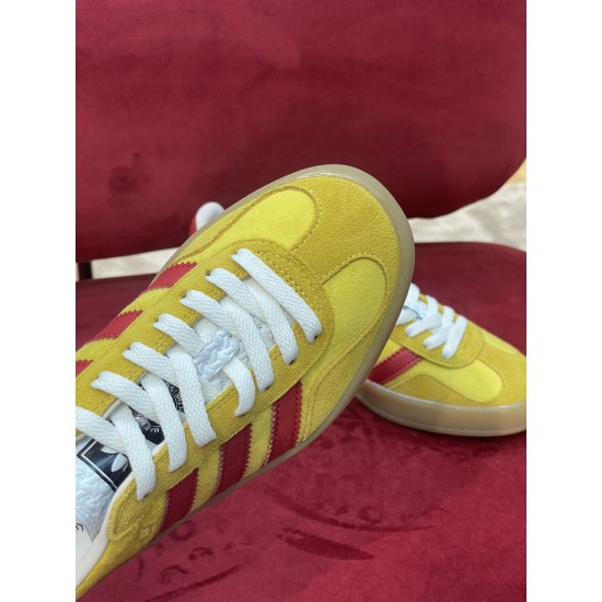 Close-up of yellow velvet toe cap and white laces on Gucci Gazelle trainer in yellow and red