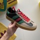 Gucci Gazelle Trainer Handheld View in black and red Hand holding Gucci Gazelle trainer showing black leather upper, red laces, and translucent gum rubber sole