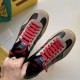 Gucci Gazelle Trainers Lacing Detail in black and red Close-up top view of Gucci Gazelle trainer pair highlighting red laces and beige suede overlays in black and red