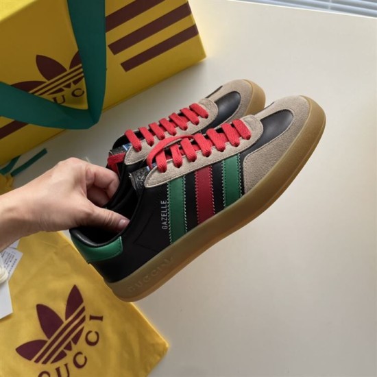 Gucci Gazelle Trainers Pair Overview in black and red Pair of Gucci Gazelle black leather trainers held in hand displaying green and red side stripes