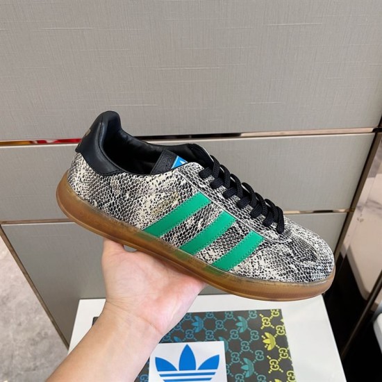 Gucci Snakeskin Pattern Low Top Trainers Grey Green Handheld Hand holding Gucci Snakeskin Pattern Low Top Trainers Grey Green