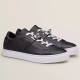 Hermes Day Black Leather Low Top Trainers Side View in black and white Side studio view of Hermes Day black leather low top trainers with white soles