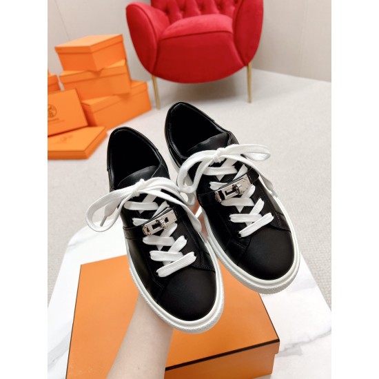 Hermes Day Black Leather Trainers Close-up View in black and white Handheld view showcasing Hermes Day black leather trainers and turn-lock clasps in black and white