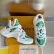 Angled View of L Archlight Green and White Footwear Angled view showing green and white trainers beside packaging