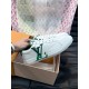 L Charlie Low Top Leather Trainers In White And Green - Side Detail Hand holding L white and green leather trainers highlighting the side logo branding