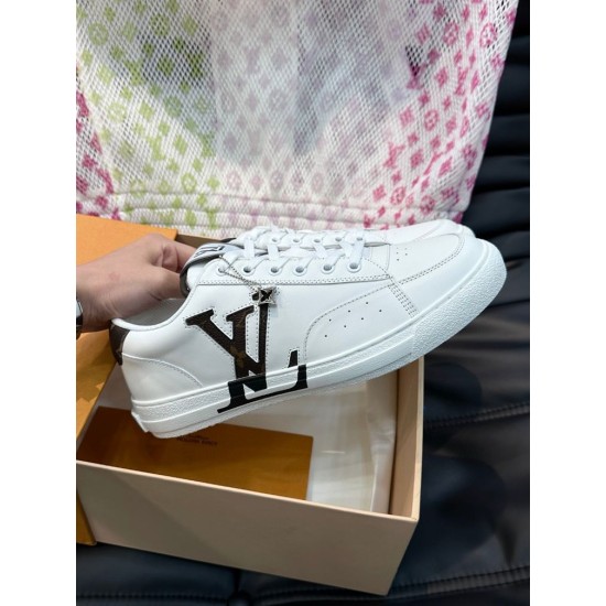 L Charlie White Trainer Lateral Profile View Side profile view of L Charlie white trainer with metallic charm held in hand above box