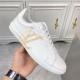 L classic white leather trainers with gold motif accent outer profile L classic white leather trainers with gold motif accent held up displaying the outer side