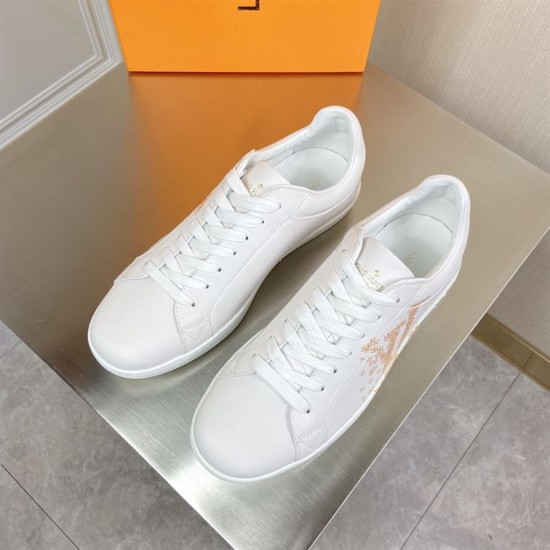 L classic white leather trainers with gold motif accent top angle view L classic white leather trainers with gold motif accent viewed from above on a table