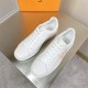 L classic white leather trainers with gold motif accent top angle view L classic white leather trainers with gold motif accent viewed from above on a table
