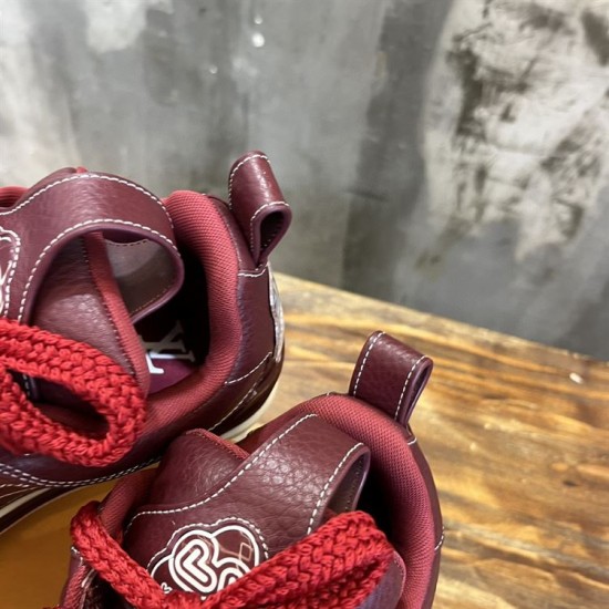 Close-up of the padded collar and heel pull tabs on burgundy trainers in burgundy and white