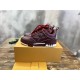 Side angle of L Skate burgundy leather low top trainers next to branded box in burgundy and white