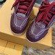 Close-up of the toe box and lacing system on burgundy leather trainers in burgundy and white