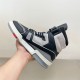 L Trainer high top leather sneaker in black and grey held in hand medial view