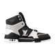 L High Top Trainer Leather Sneakers In Black And White - Profile View Profile view of the black and white L high top trainer showing side branding and sole flower details