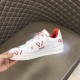 L Trainer Sneaker White Red Graphic Printed Leather Low Top Footwear lateral exterior side held against quilted backdrop