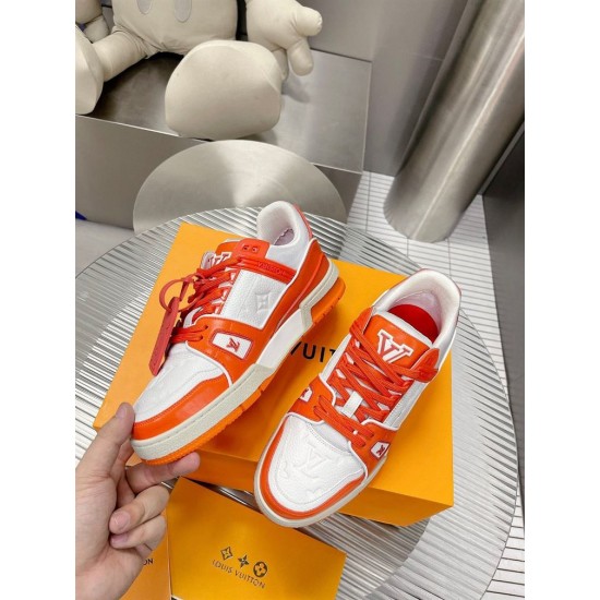 Close-up perspective of L Trainer Low Top Orange And White Leather Sneakers held in hand