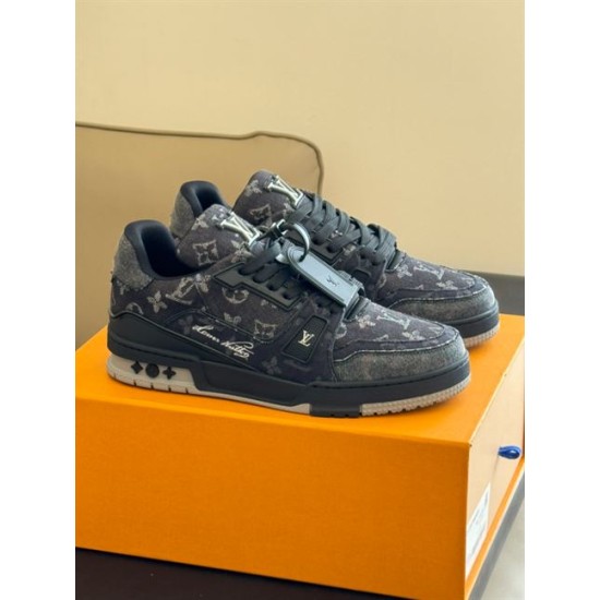 L Monogram Denim Low Top Trainer Sneakers Angle View in denim and black Angle view of L Monogram Denim Low Top Trainer Sneakers resting on orange box in denim and black