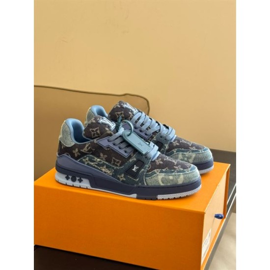Three-Quarter Front View - L Blue Denim Monogram Trainers Three-quarter front view of L blue denim monogram trainers on an orange box