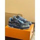 Three-Quarter Front View - L Blue Denim Monogram Trainers Three-quarter front view of L blue denim monogram trainers on an orange box
