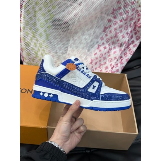 Handheld lateral view of L Trainer Rhinestone Blue White Leather Low Top Sneakers displaying side logo