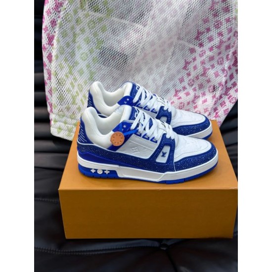 Pair of L Trainer Rhinestone Blue White Leather Low Top Sneakers resting on a branded orange box