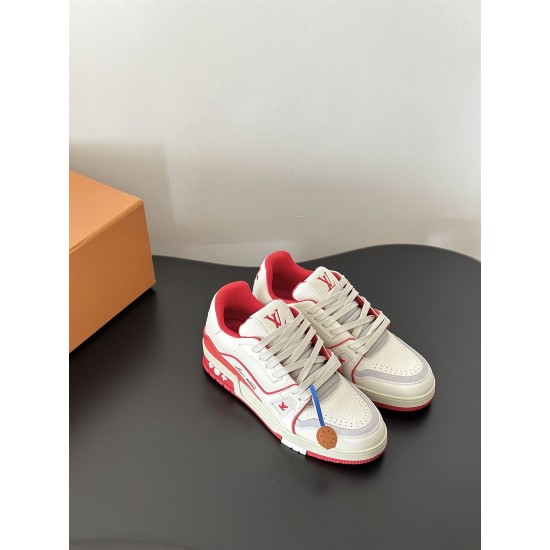 Pair of L white and red leather trainers on a dark surface