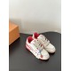 Pair of L white and red leather trainers on a dark surface