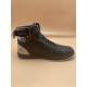 L Rivoli High-Top Leather Monogram Trainers In Black - Outer Side View Outer side perspective of the black L high-top trainers featuring the metallic buckle strap