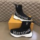 L Run Knit Sock Sneaker Boot Pair Display in black and white Pair of L Run Knit Sock Sneaker Boots in black resting next to an orange shoe box in black and white