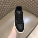 Front View - L Trainer Monogram Canvas Low Top Black Trainers in black and white Front view focusing on the laced closure and branded tongue of L Trainer Monogram Canvas Low Top Black Trainers in black and white