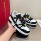 L Trainer Maxi Low-Top Trainers in white and black held in hand Handheld view showcasing L Trainer Maxi Low-Top Trainers in white and black