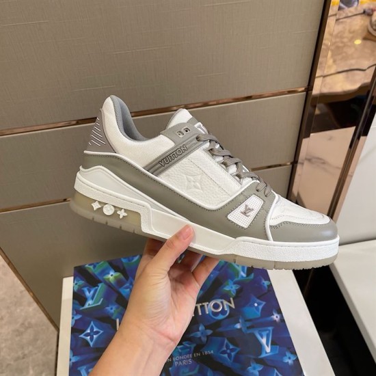 L Trainer - Handheld Lateral Perspective in grey and white Hand holding the L grey and white trainer showcasing the outer sole
