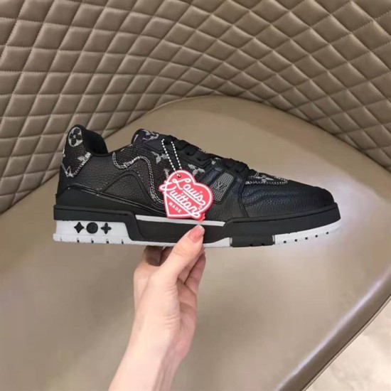 Lateral outer side of L black monogram leather trainer low top shoes held in hand in black and red