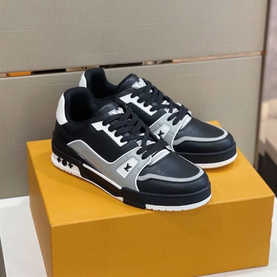 Pair of L trainer low top leather sneakers displayed on a branded box in black and grey