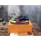 Angled View of L Colourblock Patent Canvas Trainers in multi-colour and red Angled side view of the L multi-colour trainers resting on a branded packaging box in multi-colour and red