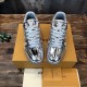Front Overhead View of L Trainer Metallic Silver Low Top Sneakers Front overhead view of L Trainer Metallic Silver Low Top Sneakers resting on packaging