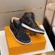 Front three-quarter angle of the brown and black L trainers Front three-quarter angle of the brown and black L trainers near a branded box