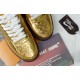 Close-up view of the perforated metallic gold toe box and laces