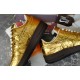 Medial side view showing printed text on metallic gold upper
