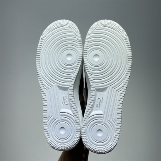 Underside view showing white rubber soles of brown trainers